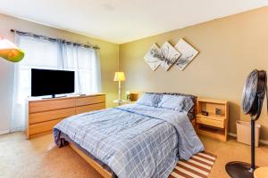 a bedroom with a bed and a flat screen tv at 3 Mi to Dtwn New Haven Colorful Condo with Yard! in West Haven