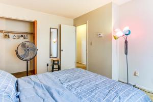 a bedroom with a blue bed and a fan at 3 Mi to Dtwn New Haven Colorful Condo with Yard! in West Haven