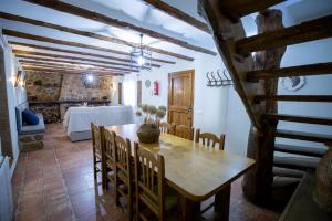 a dining room with a wooden table and chairs at Casas Rurales El Portillo in Yeste