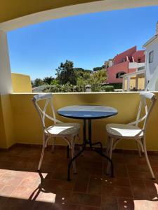une table et deux chaises sur un balcon dans l'établissement Casa Amarela, à Faro