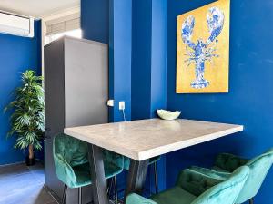 a blue room with a table and two green chairs at Cooth's Royale in Breda
