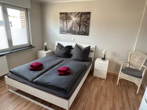 a bedroom with a bed with two red pillows on it at Fewo-H41 in Korschenbroich