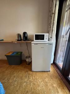 un micro-ondes posé sur un réfrigérateur dans l'établissement Casa Amarela, à Faro