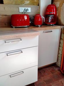 a kitchen with two red toasters on a counter at Chez les sœurs in Igé