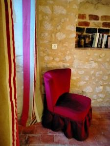 a red chair and a red ottoman in a room at Chez les sœurs in Igé