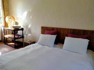 a bedroom with a large white bed with two pillows at Chez les sœurs in Igé