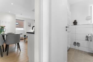 a kitchen and dining room with white walls and a table at Haus Klaus Lucky in Norderney