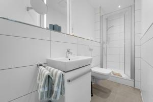 a white bathroom with a sink and a toilet at Haus Klaus Lucky in Norderney