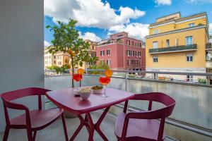 een roze tafel en stoelen op een balkon bij Cipro Vatican Luxury Escape in Rome