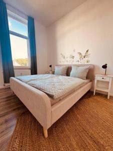 a bedroom with a large bed with a large window at FeWo Nordseebrise in Wilhelmshaven