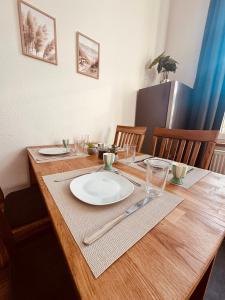 a wooden table with a white plate on top of it at FeWo Nordseebrise in Wilhelmshaven