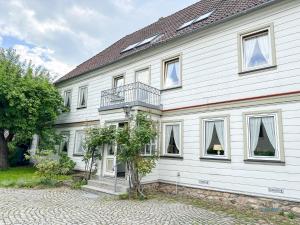 a white house with a balcony on it at Landhaus Stolper Wohnung 3 in Herzberg am Harz