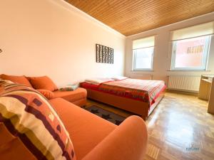 a living room with a couch and a bed and windows at Landhaus Stolper Wohnung 3 in Herzberg am Harz