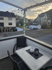 a table on a balcony with a view of a street at Hakans Moselblick Ferienwohnung in Treis-Karden
