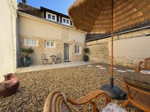 厄尔河畔帕西Charmante Maison avec Jardin Privé - PACY SUR EURE的带遮阳伞、桌椅的露台