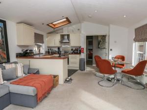 a living room and kitchen with a couch and a table at Gressingham View Lodge in Carnforth