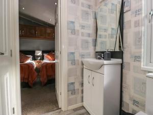 a bathroom with a sink and a bedroom with a bed at Gressingham View Lodge in Carnforth +21 photos