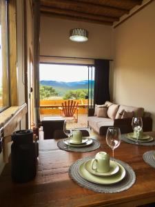 a living room with a table with plates and wine glasses at Cabana Bariloche - Busch Camping in Rancho Queimado
