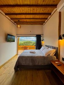 a bedroom with a large bed and a large window at Cabana Bariloche - Busch Camping in Rancho Queimado +45 photos