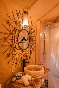 a bathroom with a sink and a mirror on a wall at Merzouga Nomads Camp in Merzouga +46 photos