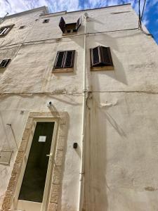 a white building with a door and windows on it at La Casa Al Mare in Polignano a Mare +5 photos
