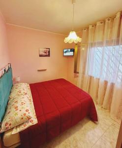 a bedroom with a red bed and a window at Villa Nausica fronte mare - A in Torre Lapillo