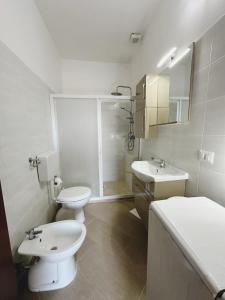 a bathroom with two sinks and a toilet and a shower at Villa Nausica fronte mare - A in Torre Lapillo