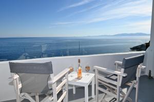 a table with two bottles of wine and two chairs at Dreamview Tinos in Kardiani