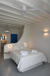 una camera con un letto bianco e un soffitto bianco di Dreamview Tinos a Kardhianí