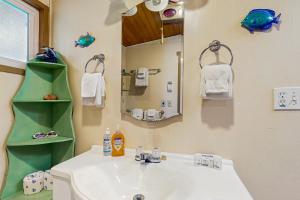 a bathroom with a sink and a mirror at Dulcinea's Cabin in Yachats