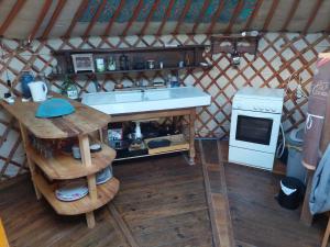 a kitchen with a sink and a stove in a yurt at La yourte au cœur de la Normandie in Boudeville