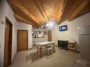 cocina con mesa y TV en el techo en Villino Nausika fronte mare - B, en Torre Lapillo