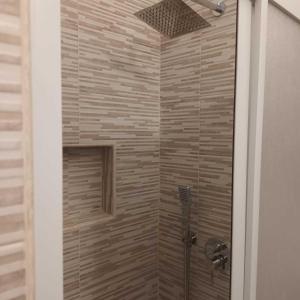 una ducha en un baño con puerta de cristal en Villino Nausika fronte mare - B, en Torre Lapillo