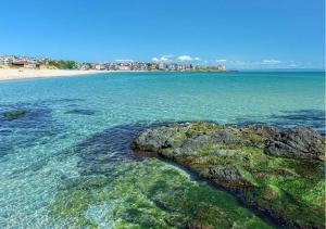 a beach with a rock in the water at Apart-Hotel Onegin & Thermal Zone in Sozopol