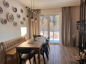 维斯瓦River Park Wisła Premium的一间有桌子、椅子和窗户的餐厅 更多4张照片