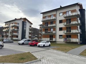 维斯瓦River Park Wisła Premium的建筑物前停放汽车的停车场