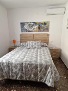 a bedroom with a bed and a painting on the wall at Alfer in Cazorla