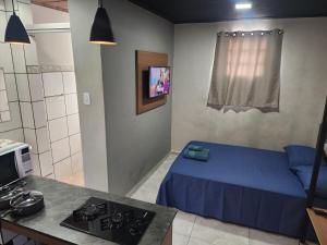 a small room with a bed and a kitchen at Kitnet mobiliada em Lins in Lins
