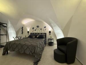 Un dormitorio con una cama y una silla negra. en Thangima, en Gallipoli
