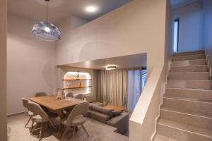 a dining room with a table and a staircase at Anemelia Villas in Karpathos Town