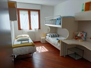 a small room with two bunk beds and a desk at Casa Terzi in Bologna