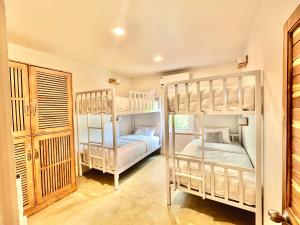 通萨拉Hi Sea Hostel - Seaside Comfort - 10mn from Pier的带门的房间设有两张双层床