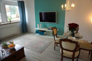 a living room with a table and a tv at Apartment Miesmuschelparadies in Lübeck