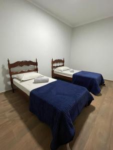 two beds in a room with blue sheets on them at Casa Oliva in Franca