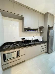 a kitchen with white cabinets and a stove and refrigerator at Casa Oliva in Franca +4 photos