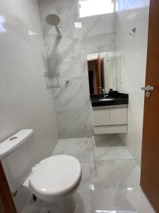 a white bathroom with a toilet and a sink at Casa Oliva in Franca