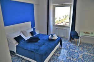 a blue bedroom with a bed and a desk at Terrazza Marconi in Salerno