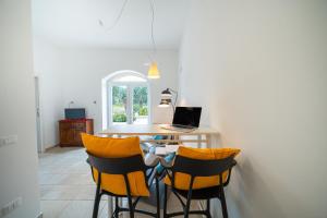 a dining room with a table with a laptop on it at Pool & Private Parking DONNA LINA in Conversano