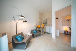 a living room with two chairs and a kitchen at Pool & Private Parking DONNA LINA in Conversano