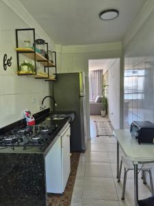 サン・ビセンテにあるCantinho do Sol e Marのキッチン(シンク、冷蔵庫、テーブル付)